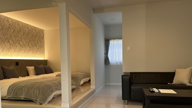 Une chambre à coucher moderne avec un lit, un canapé et une table basse.