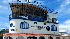 A hotel named Hotel Perla Azul with a distinctive blue and white color scheme, featuring a large sign with the hotel's name and a rooftop terrace. - Hotel Perla Azul (Girardot)