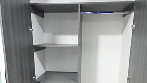 A closet with multiple shelves and a hanging rod. - Hotel Perla Azul (Girardot)