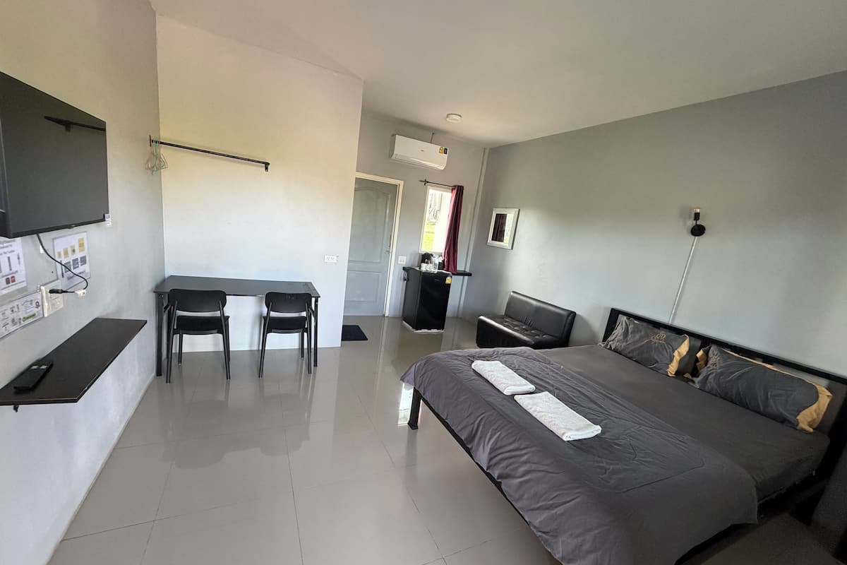 Ein Schlafzimmer mit Bett, Schreibtisch und Stuhl.