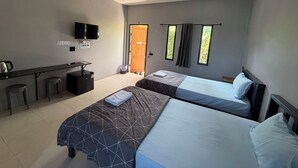 A hotel room with two beds, a desk with a chair, a TV, and a window with curtains.