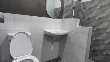 Een badkamer met toilet, wastafel en douche.