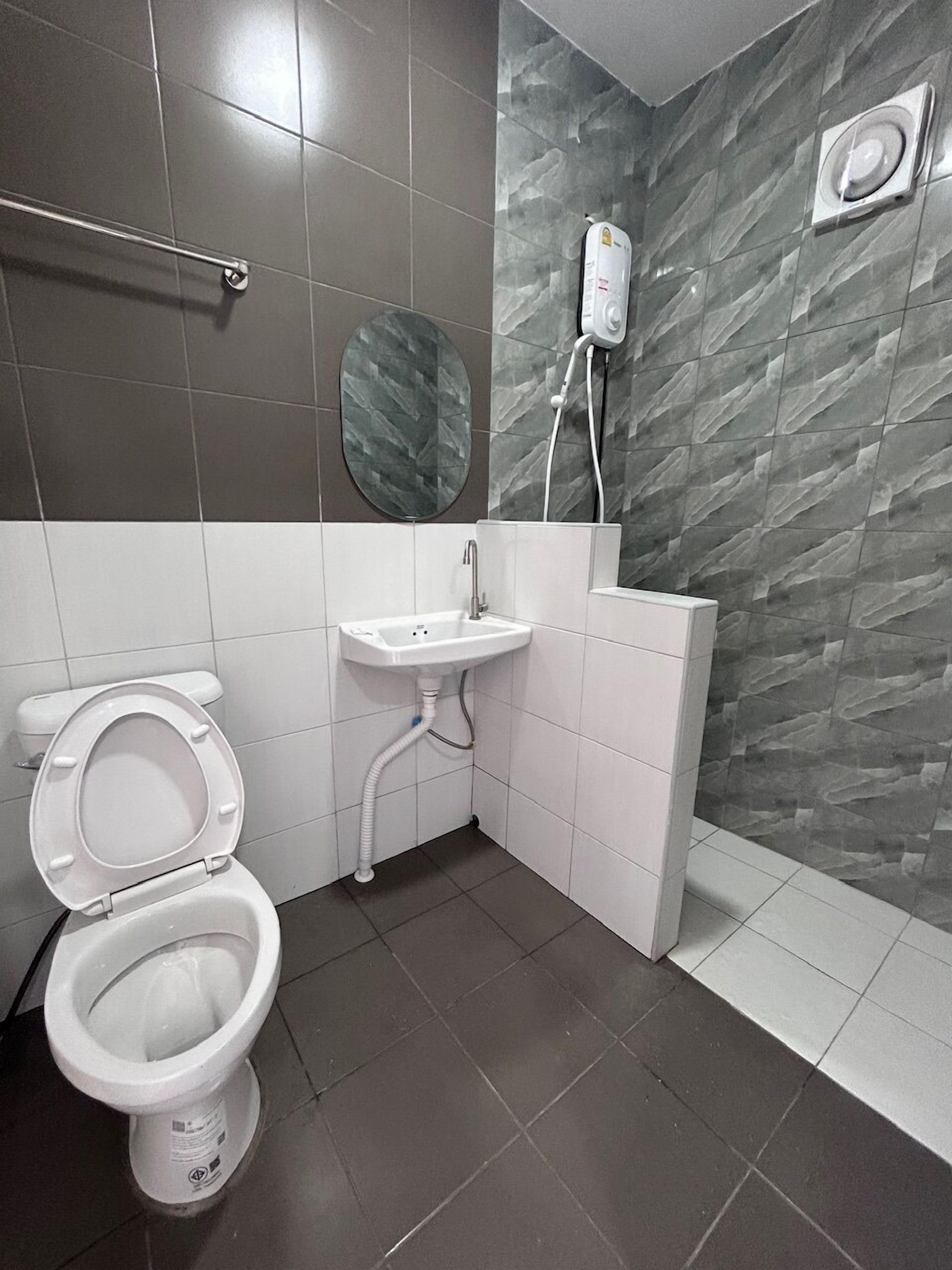 Un baño moderno con inodoro, lavamanos y ducha.