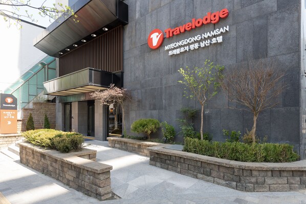 A Travelodge hotel entrance with a stone facade, a modern entrance, and well-maintained landscaping. - Travelodge Myeongdong Namsan (Seoul)