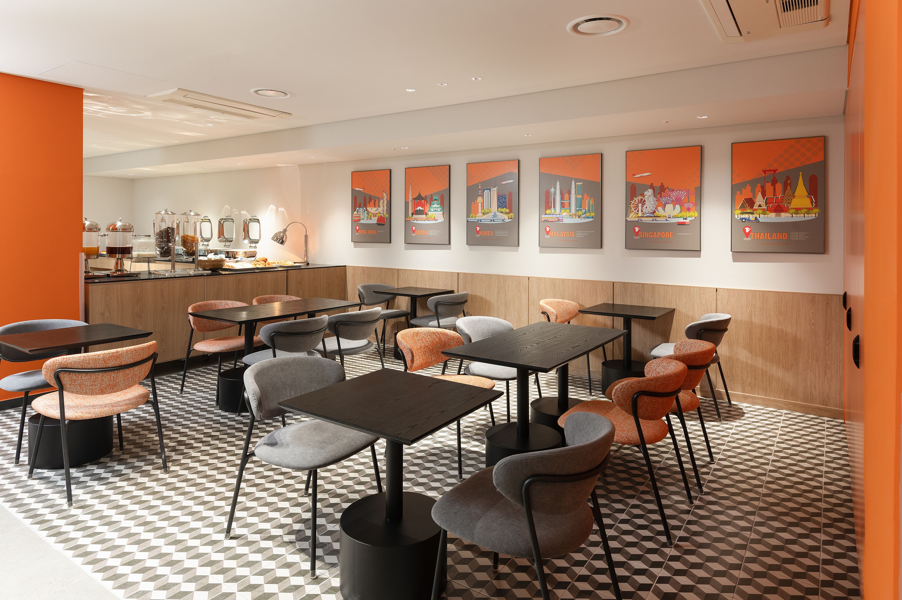 A modern cafe with a checkered floor, multiple seating areas, and city-themed artwork on the walls.