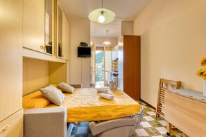 Une chambre à coucher avec un lit, un bureau, une chaise et un téléviseur.