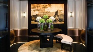Un espace repas moderne avec une table ronde, un banc et un grand tableau accroché au mur.