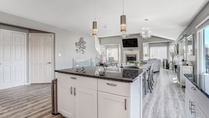 A modern kitchen with white cabinets, a granite countertop, and pendant lighting. - Casa De Claudia (Colorado Springs)