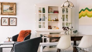 Un coin repas comprenant un buffet blanc, une table en bois et deux chaises.