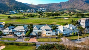 Un campo de golf con un club de campo y edificios residenciales.