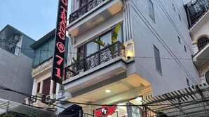 Un edificio con un letrero destacado que dice "PHUONG TRA" y un balcón con barandilla.
