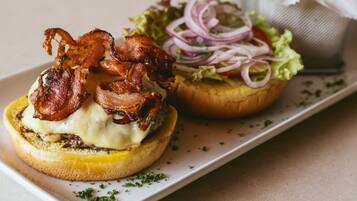 Un sándwich de tocino y queso en pan, acompañado de papas fritas.
