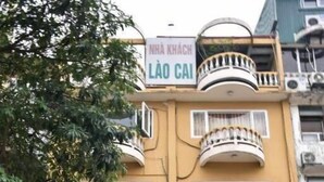 A building with balconies and a sign reading "NHÀ KHÁCH LÀO CÁI". - Lao Cai Hotel by Bay Luxury (Hanoi)