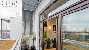 Um imóvel residencial com varanda, plantas em vasos e um deck de madeira.