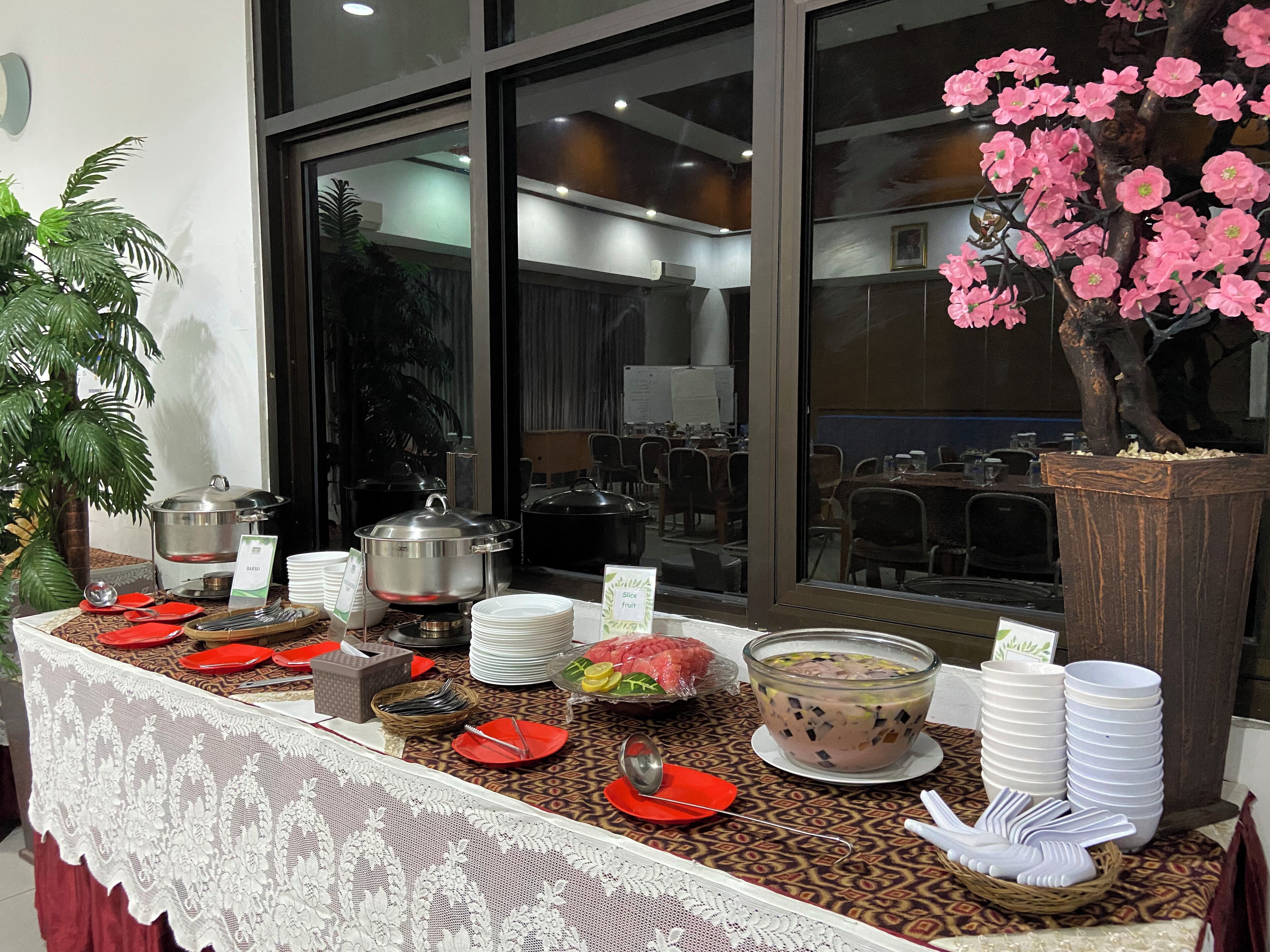 Un buffet con diversi piatti e un albero decorativo rosa.