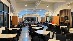 A spacious dining area with high ceilings, modern lighting, and a central serving station. - Graha Widya Bhakti at STIESIA Surabaya (Surabaya)