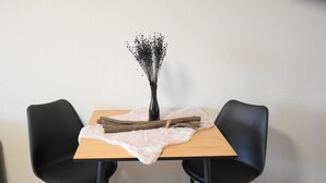 A table with a vase of dried flowers, a wooden log, and a fur throw. - Charming Homes - Studio 25 (Weyhausen)