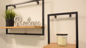 Two wall-mounted shelves with a potted plant and a candle. - Charming Homes - Studio 25 (Weyhausen)