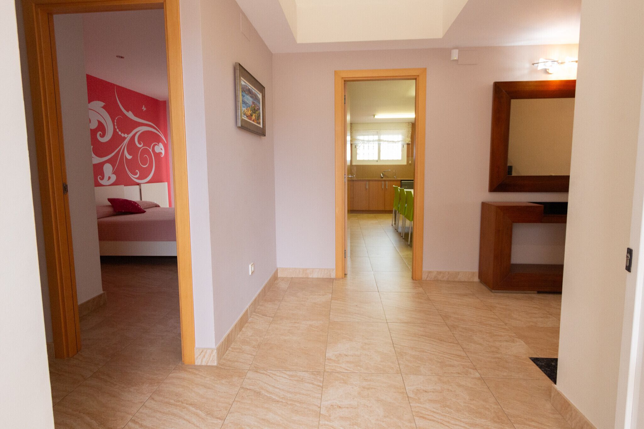 Un couloir donnant sur une chambre, une cuisine et une salle de bain.
