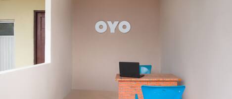 A room with a brick desk, a laptop, and a blue chair.