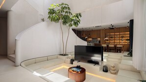 Um interior espaçoso com uma escadaria moderna, área de estar e espaço para refeições.