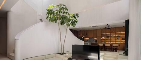 A spacious interior with a modern staircase, a seating area, and a dining space.