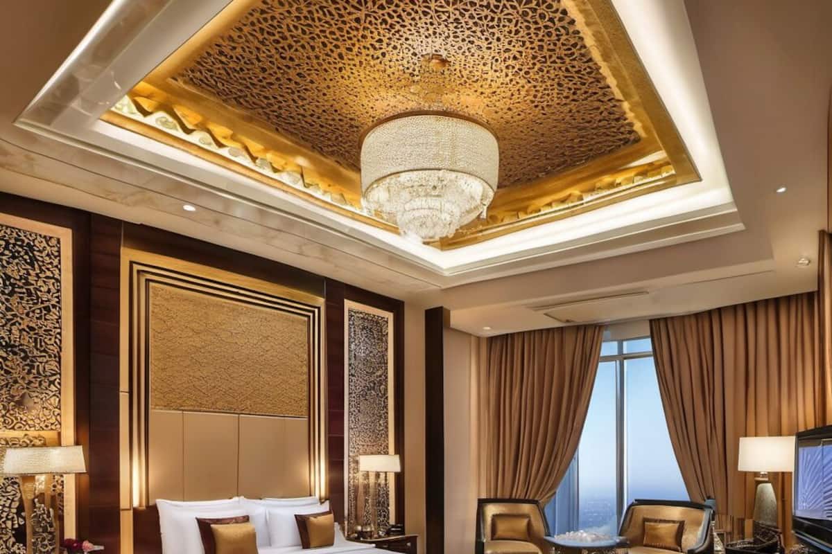 A luxurious hotel room with a large bed, a seating area with a sofa and armchairs, a television, and a view of the city.