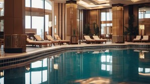Ein moderner Poolbereich im Innenbereich mit Liegestühlen und einer großen Kronleuchter.