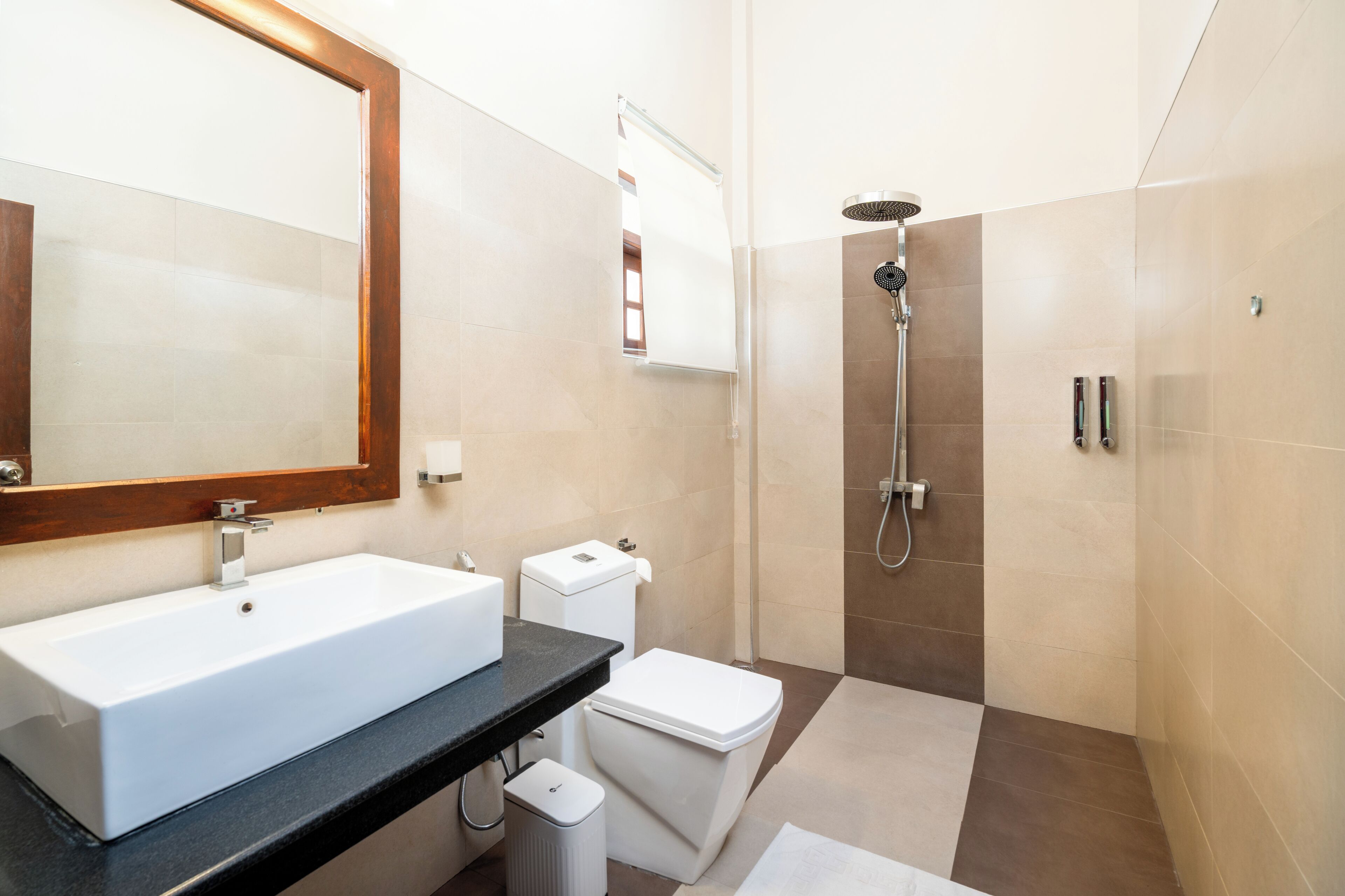 Un baño moderno con un lavamanos grande, inodoro y ducha.