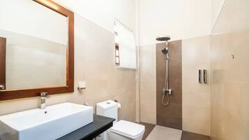 Un baño moderno con un lavamanos grande, inodoro y ducha.