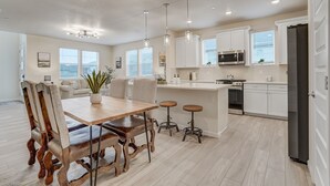 A modern kitchen with white cabinets, stainless steel appliances, and a central island. - Rio Grande (Colorado Springs)