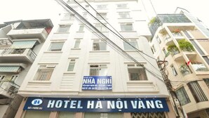 A multi-story building with a sign for "HOTEL HA NOI VANG" and another sign for "NHA NGHI". - Ha Noi Vang Hotel by Bay Luxury (Hanoi)