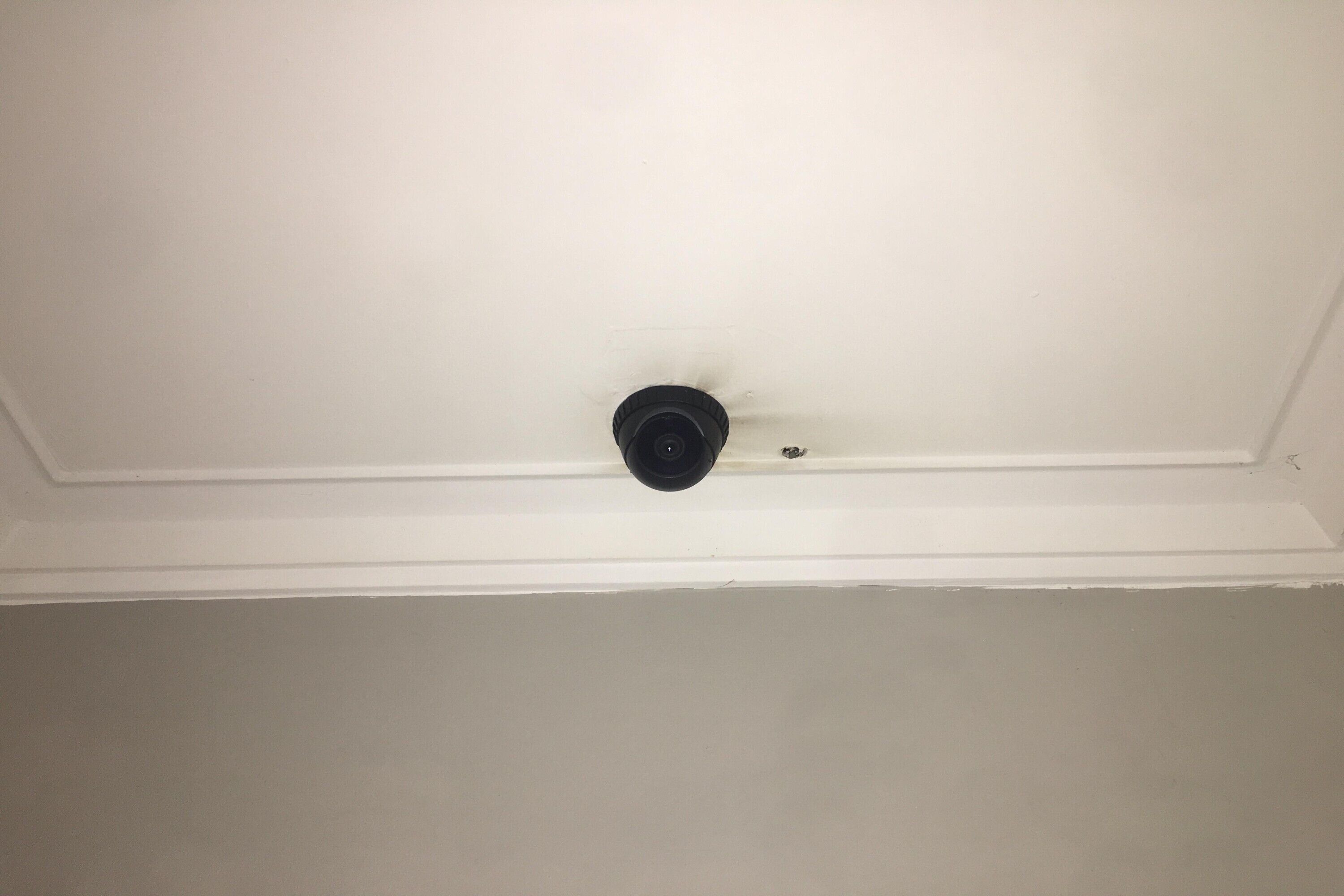 A white ceiling with a black smoke detector.