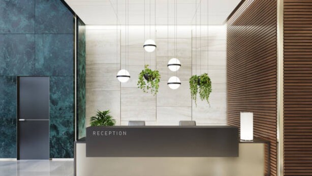 A reception area with a marble wall, a reception desk, hanging plants, and pendant lights. - OYO 93543 Belmount Residence Near SILOAM CLINIC MERUYA (Jakarta)
