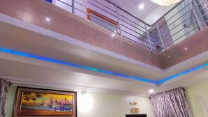 A multi-level room with a staircase, a ceiling fan, a painting, and a sign indicating a conference room. - VICPEALIA HOTEL LTD (Uyo)