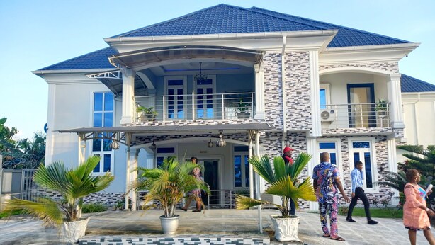 A two-story house with a curved roof, a balcony, and a tiled entrance. - VICPEALIA HOTEL LTD (Uyo)