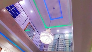 A room with a high ceiling, decorative lighting, and a chandelier. - VICPEALIA HOTEL LTD (Uyo)