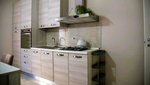Una cocina moderna con electrodomésticos integrados, una estufa a gas y una campana extractora de acero inoxidable.