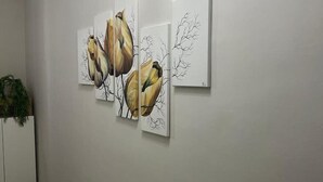 Un pasillo con tres cuadros enmarcados que representan aves y ramas.