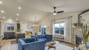 Una sala moderna con un sofá seccional azul, una mesa de centro y una chimenea.