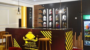 A hotel reception area with a bar, a minibar, and a logo for Davis Hotel Suites. - DAVIS HOTEL & SUITES (Port Harcourt)