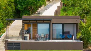 Uma casa moderna com área de refeições, cozinha e escada que leva a um deck.
