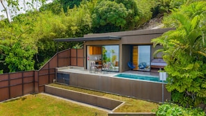 Une maison moderne dotée d’une piscine, d’un espace extérieur aménagé et d’un coin cuisine.
