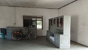 A room with a tiled floor, a bicycle, a cabinet, and a window with blinds. - Hotel O Pondok Gusang Kuala Near Pelabuhan H Basran (Sampit)