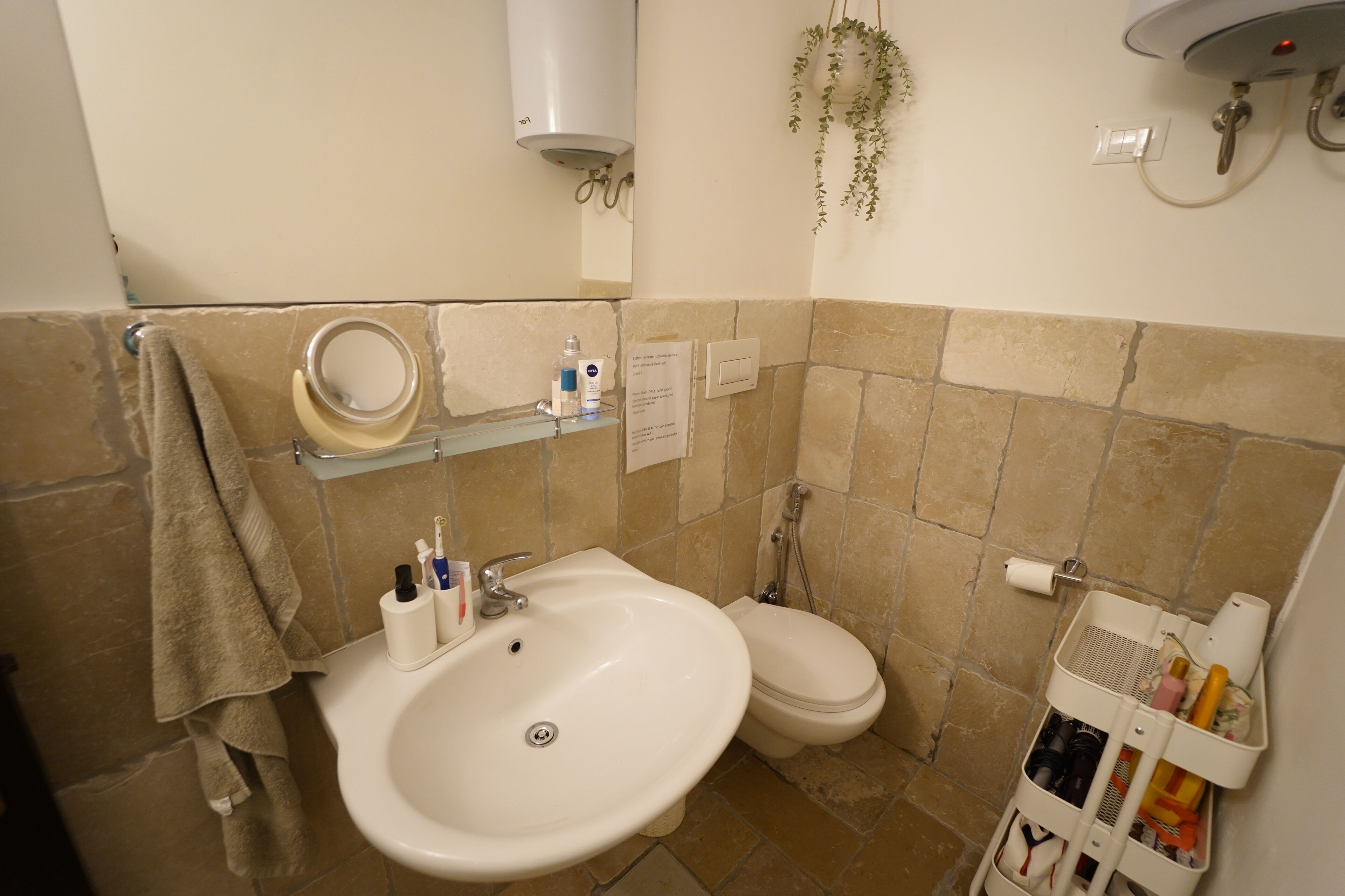 A bathroom with a sink, toilet, and a towel rack.