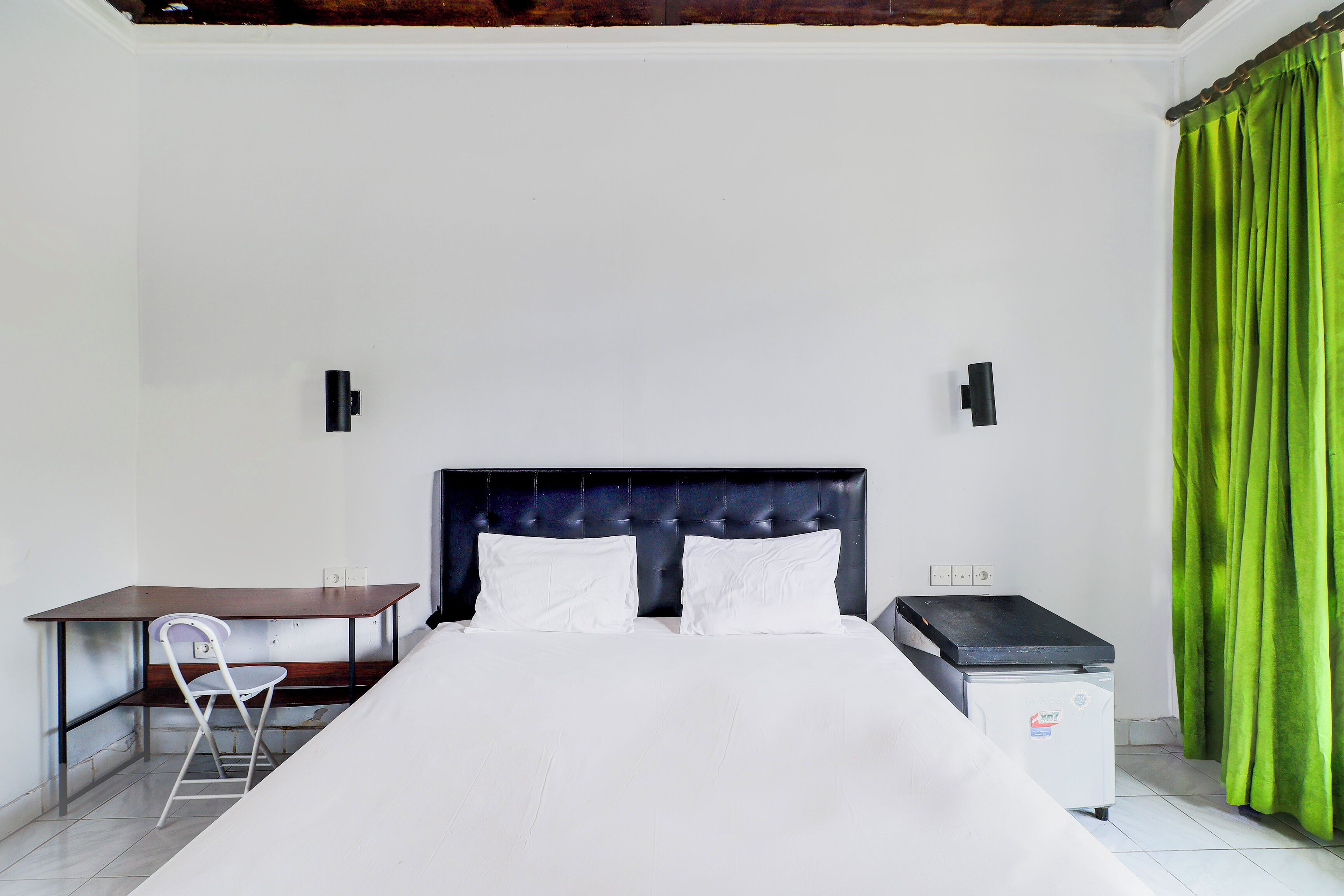 Een netjes ingerichte hotelkamer met een bed, een bureau en een stoel.