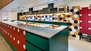 Une cuisine moderne dotée d’un îlot central, d’un four à micro-ondes et d’un dosseret en carreaux hexagonaux.