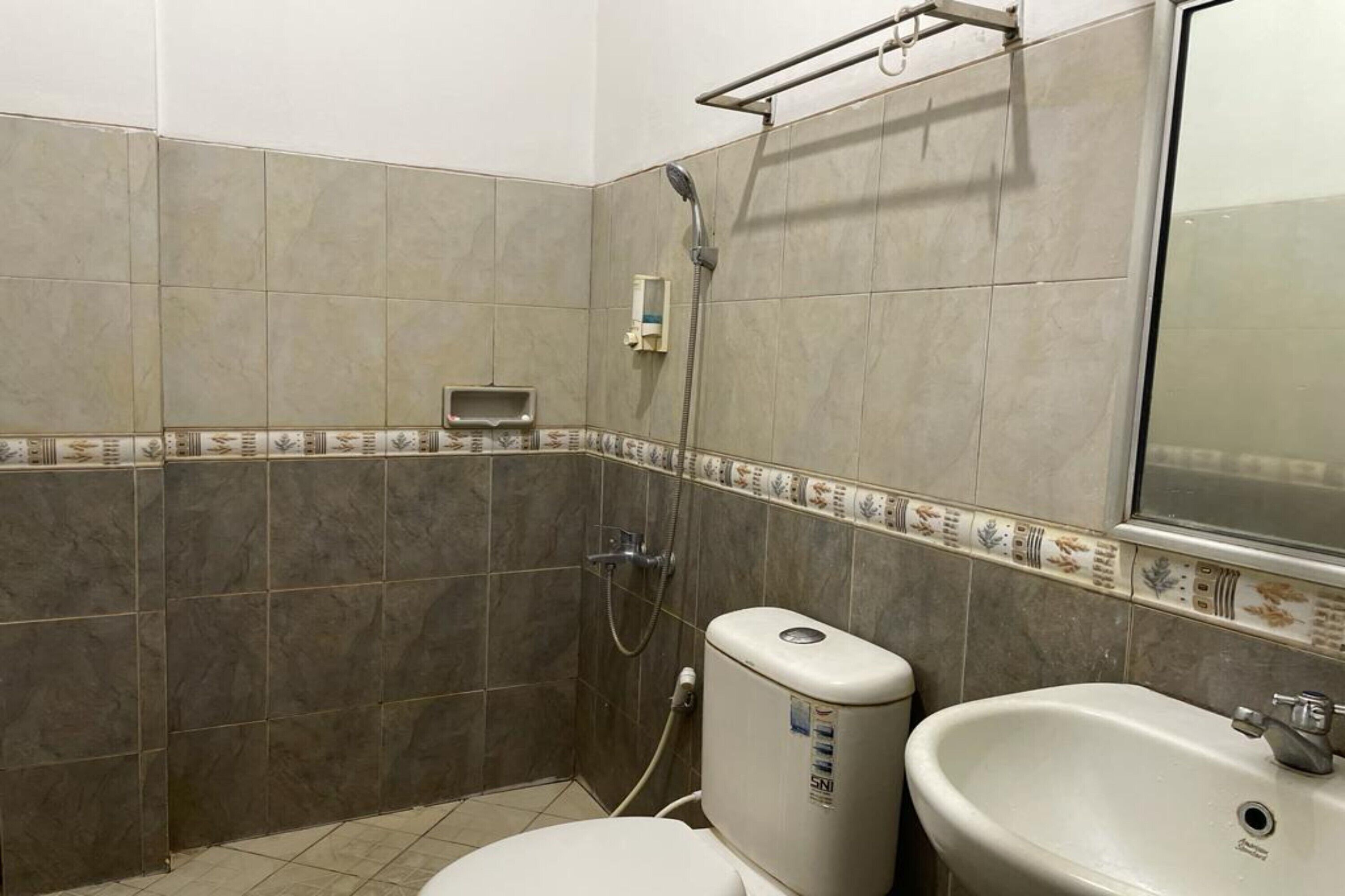 A bathroom with a toilet, sink, and shower.