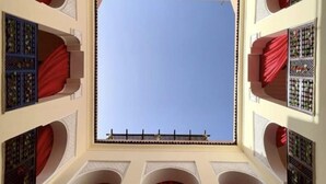 A room with a large central window, arched doorways, and decorative metal grilles. - Riad Sassa Finda (Marrakech)
