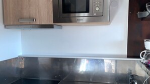 Keittiössä on mikroaaltouuni, pesuallas ja ruostumattomasta teräksestä valmistettu työtaso.